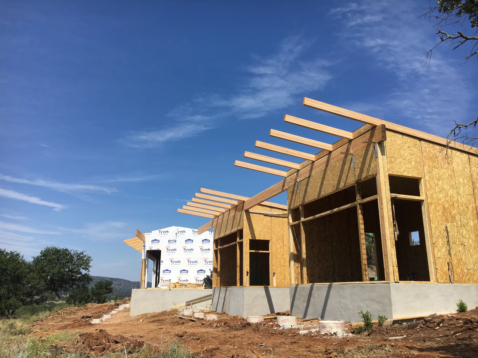 SIP shell of the hunting cabin on its stem wall, rafter tails running out over the openings